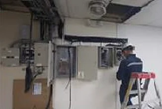 Técnico de ASISTEC trabajando en tableros eléctricos de un edificio